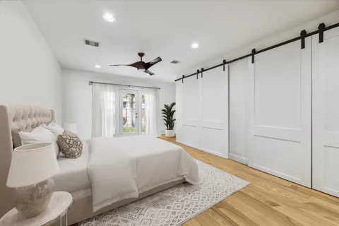 a living room with furniture a flat screen tv and a wooden floor