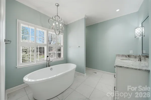 a white bath tub sitting next to a bathroom sink