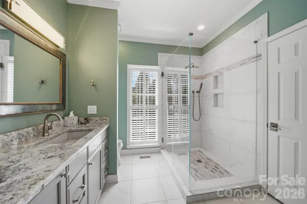 a bathroom with a granite countertop sink a shower and a mirror