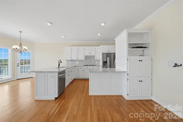 a kitchen with kitchen island wooden floors appliances and cabinets