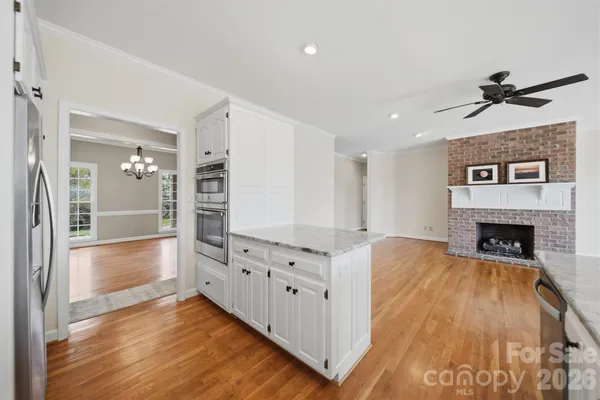 a view of a hallway with wooden floor and a fireplace
