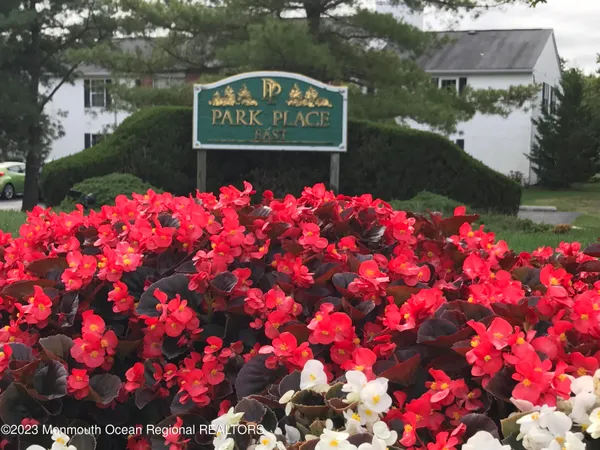 a sign that is sitting in front of flowers
