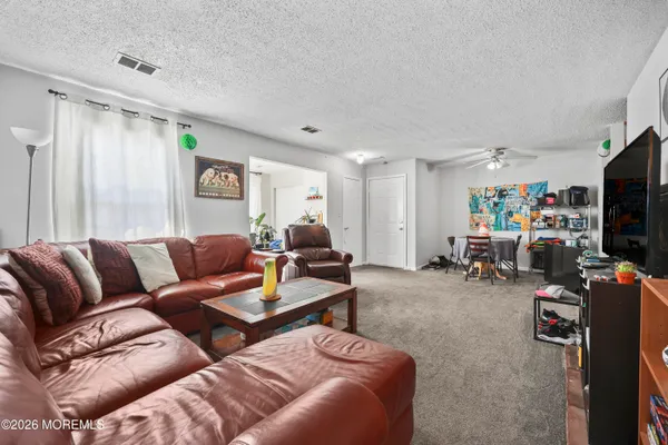 a living room with furniture a flat screen tv and a window
