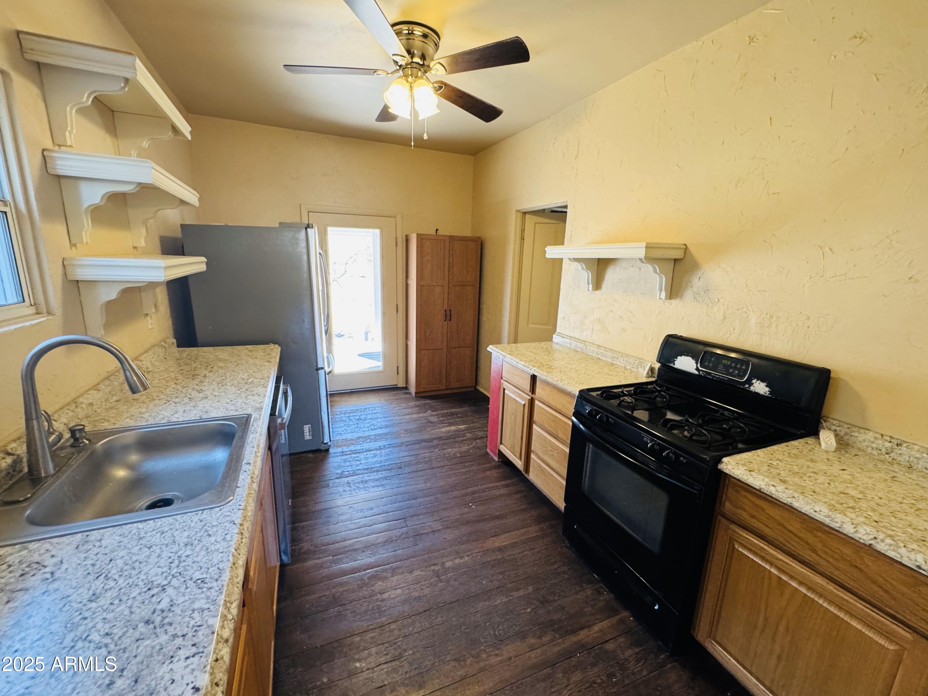507 Bisbee Road Bisbee, AZ 85603 - Photo 17 of 26 a kitchen with granite countertop a stove and a sink