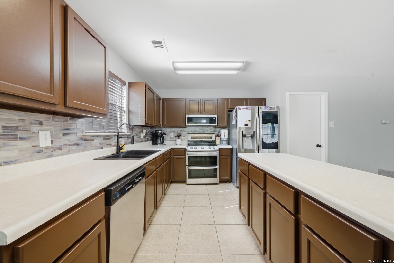 11622 Shotgun Way Helotes, TX 78023 - Photo 12 of 35 a kitchen with stainless steel appliances a sink stove and cabinets