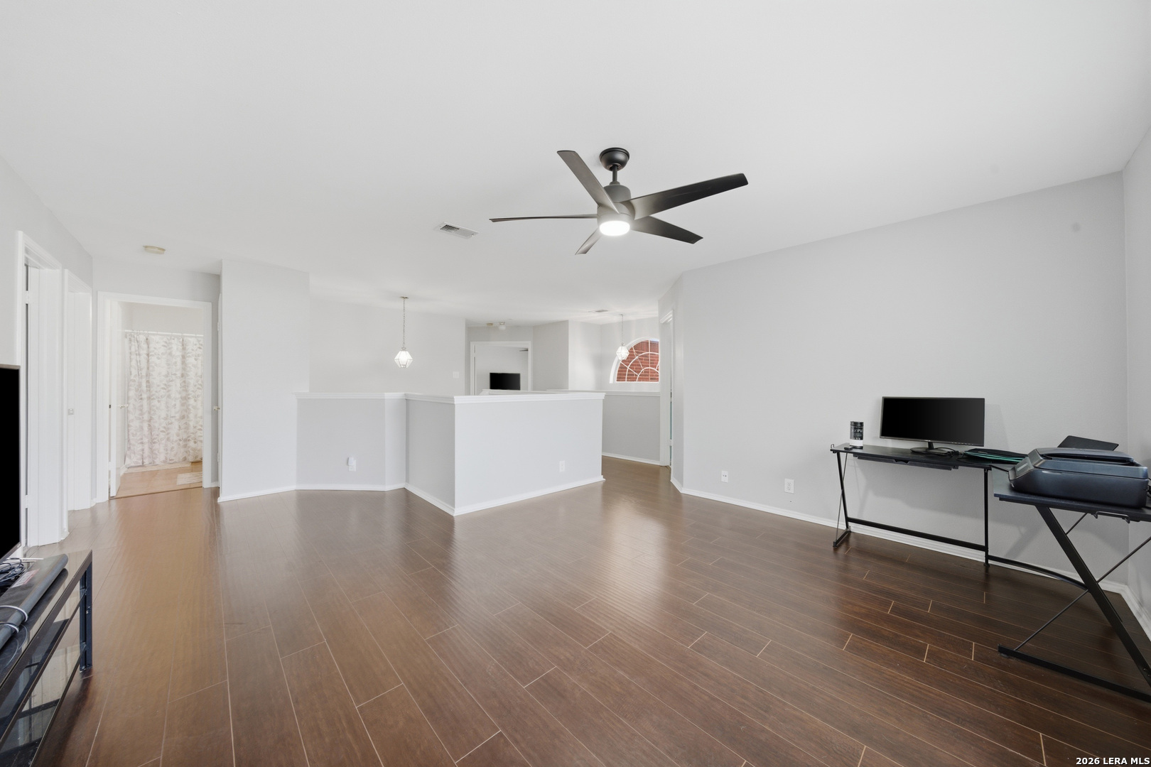 11622 Shotgun Way Helotes, TX 78023 - Photo 22 of 35 a view of an empty room with wooden floor and a ceiling fan