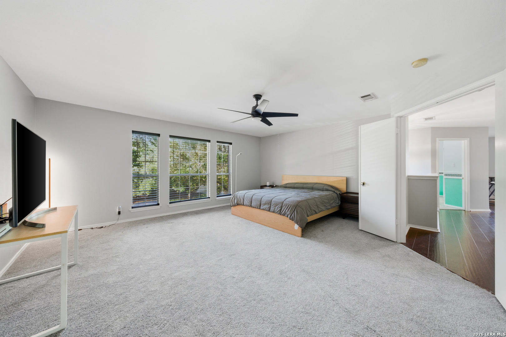 11622 Shotgun Way Helotes, TX 78023 - Photo 23 of 35 a spacious bedroom with a bed and a flat screen tv