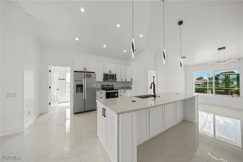 a bedroom with a bed a chandelier and a couch