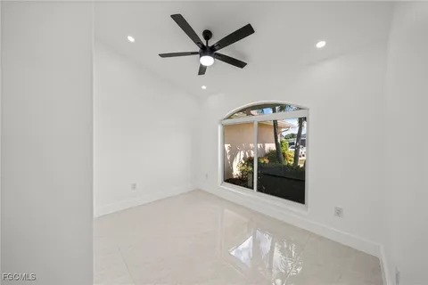 an empty room with a ceiling fan and a window