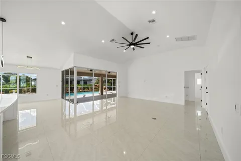 an empty room with windows and ceiling fan