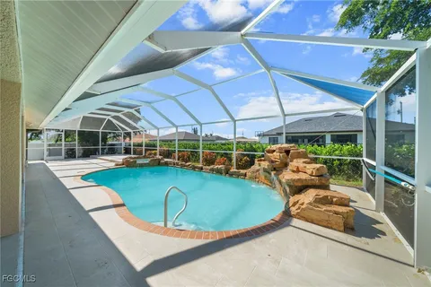 a view of a swimming pool with lawn chairs and a big yard