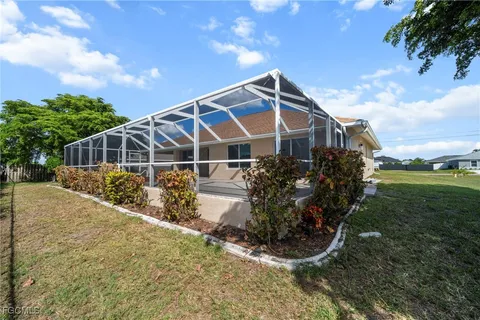 a view of a house with a yard and wooden fence
