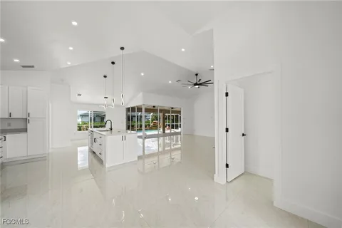 a kitchen with white cabinets and window