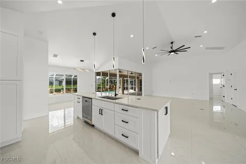 a large white kitchen with lots of counter space and appliances