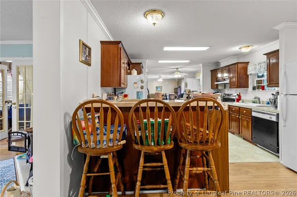 a kitchen with stainless steel appliances a refrigerator a sink dishwasher stove top oven and cabinets