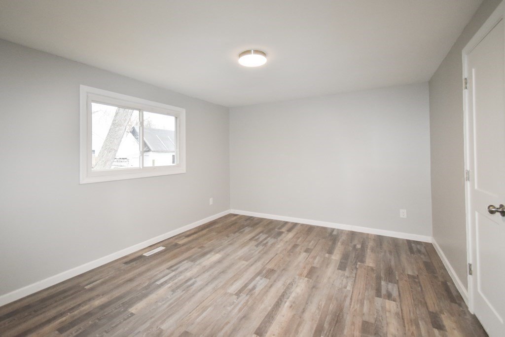 1094 Sumner Avenue Springfield, MA 01118 - Photo 16 of 35 an empty room with wooden floor and windows