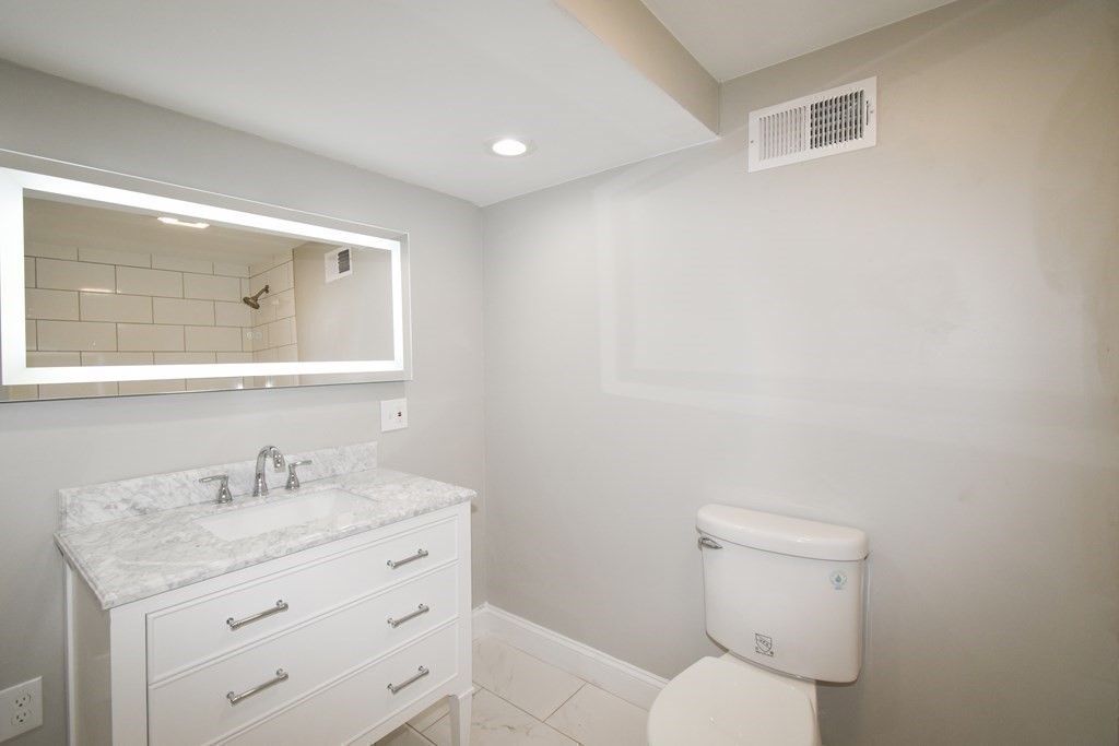 1094 Sumner Avenue Springfield, MA 01118 - Photo 20 of 35 a bathroom with a granite countertop toilet sink and mirror