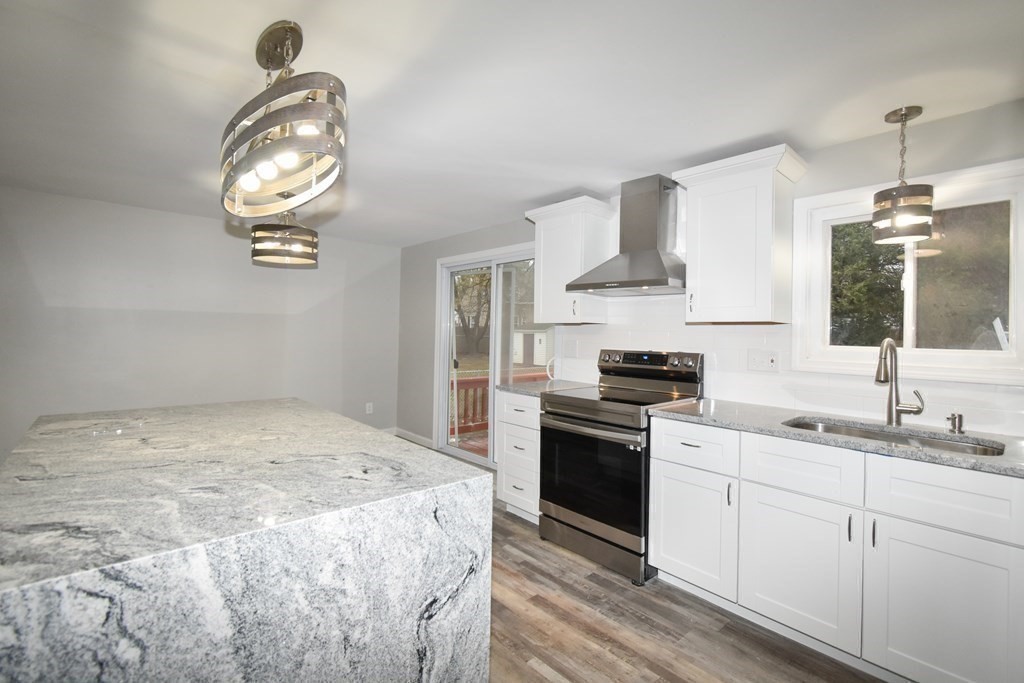 1094 Sumner Avenue Springfield, MA 01118 - Photo 6 of 35 a kitchen with a stove cabinets and a wooden floor