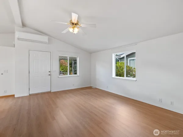 an empty room with wooden floor and windows