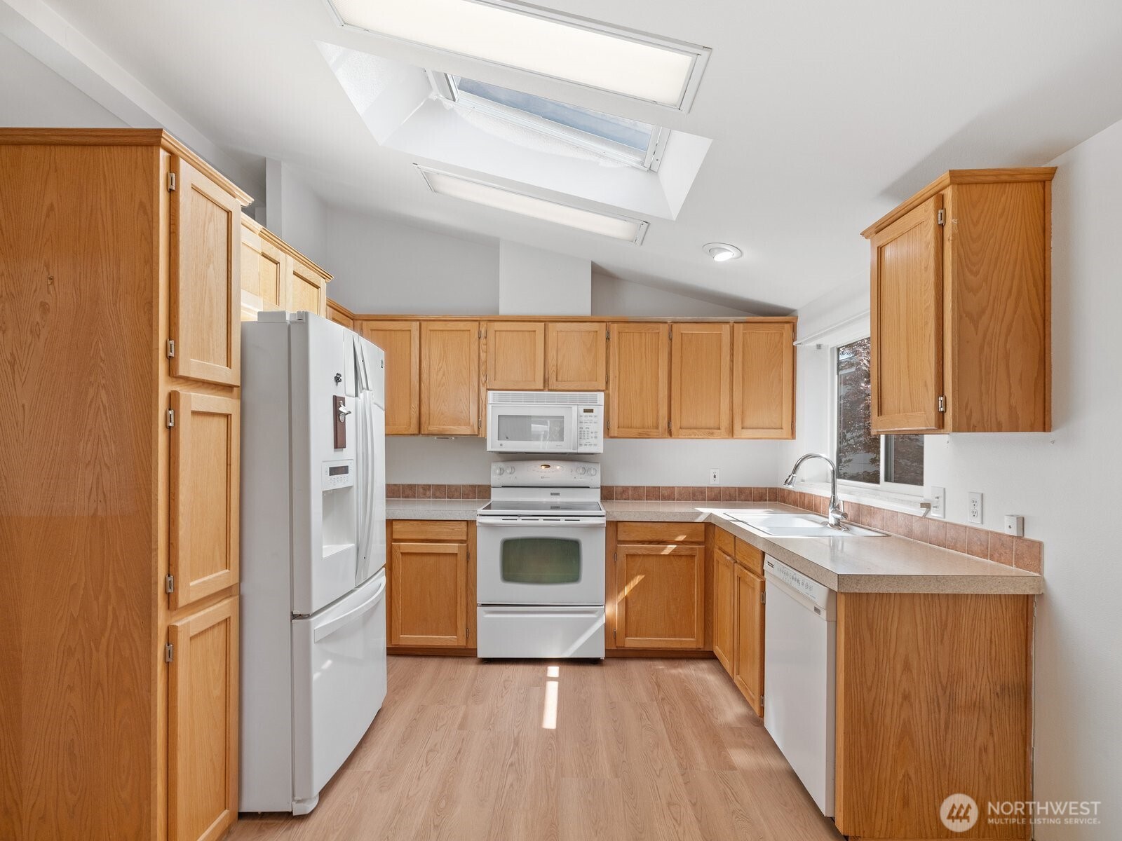 23825 15th Avenue Southeast, Unit 159 Bothell, WA 98021 - Photo 6 of 20 a kitchen with stainless steel appliances granite countertop a refrigerator a sink dishwasher a stove with wooden cabinets and floor