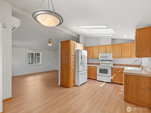 a kitchen with a refrigerator a stove top oven and sink