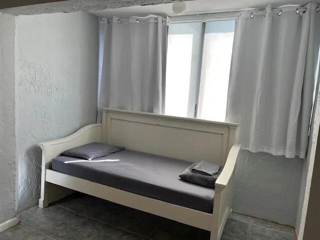 a bedroom with a bed and a lamp with window