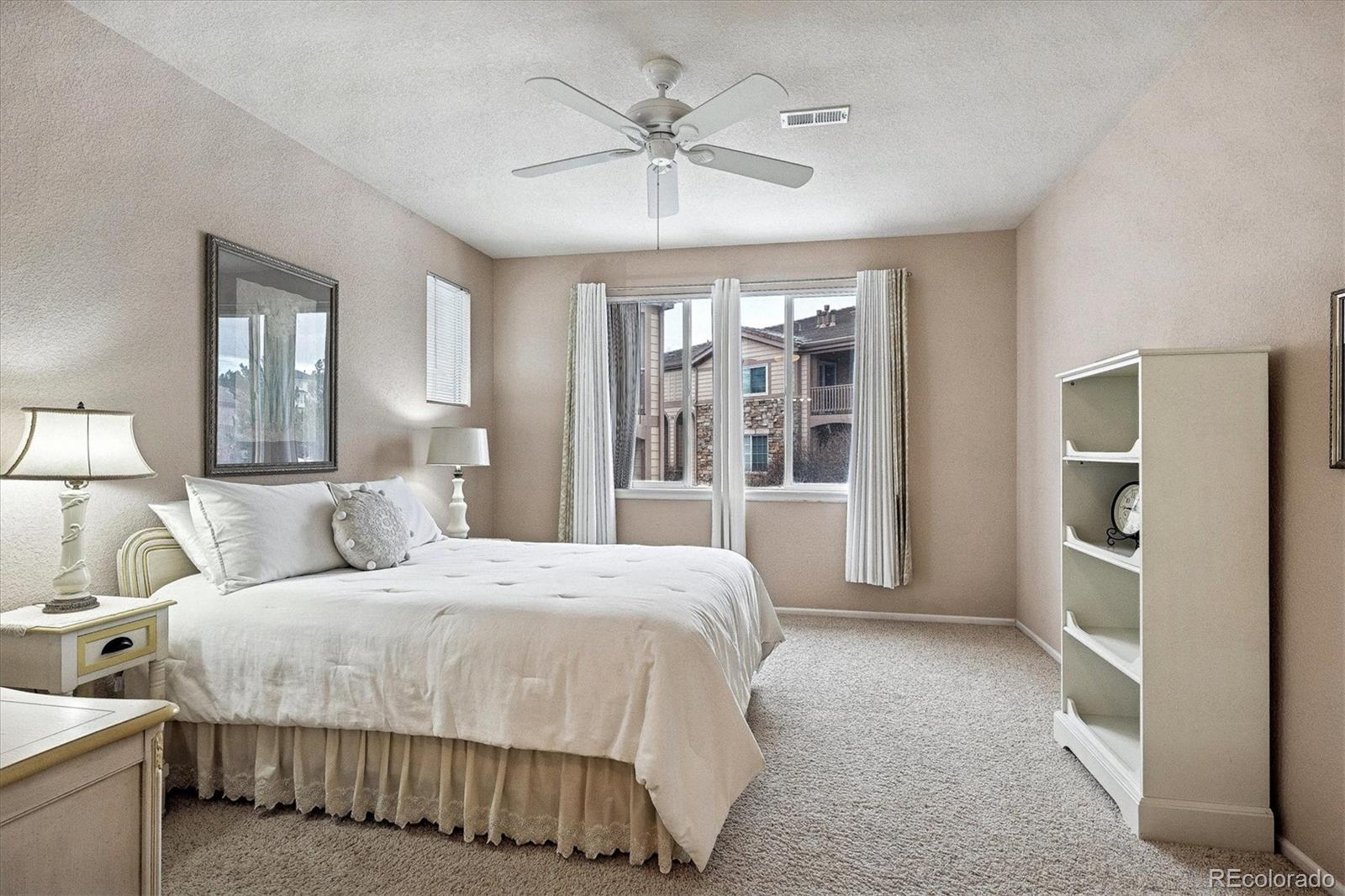 22960 East Roxbury Drive, Unit F Aurora, CO 80016 - Photo 14 of 43 a bedroom with a large bed and a chandelier