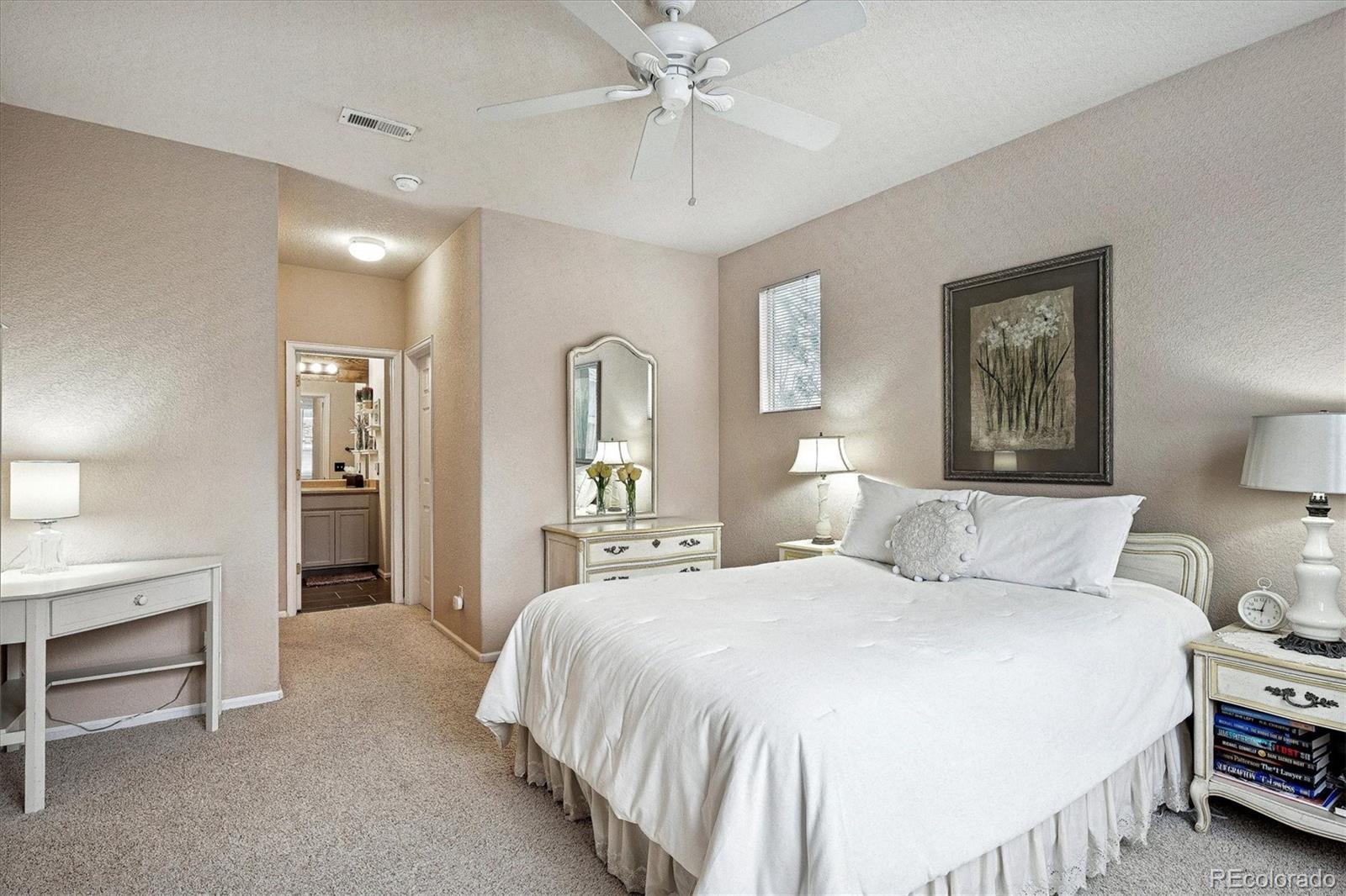 22960 East Roxbury Drive, Unit F Aurora, CO 80016 - Photo 15 of 43 a bedroom with a large bed and a chandelier