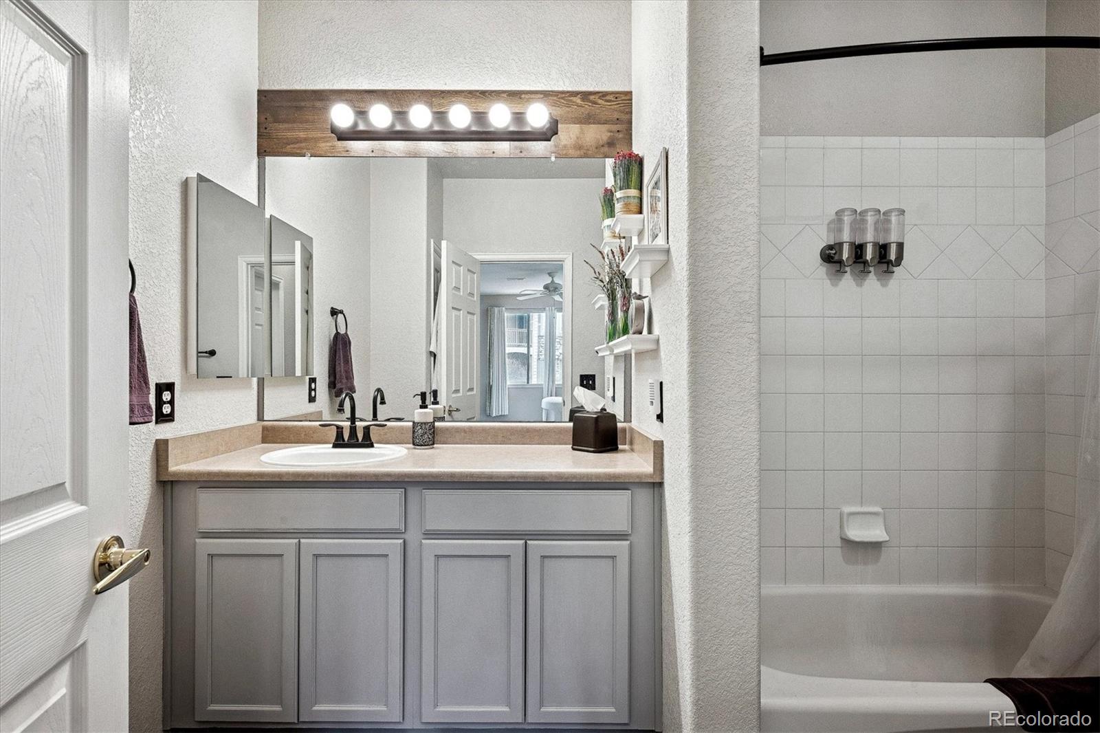 22960 East Roxbury Drive, Unit F Aurora, CO 80016 - Photo 16 of 43 a bathroom with a double vanity sink and a mirror