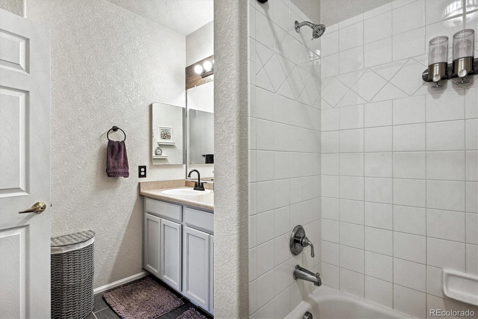 22960 East Roxbury Drive, Unit F Aurora, CO 80016 - Photo 17 of 43 a bathroom with a sink a toilet and shower