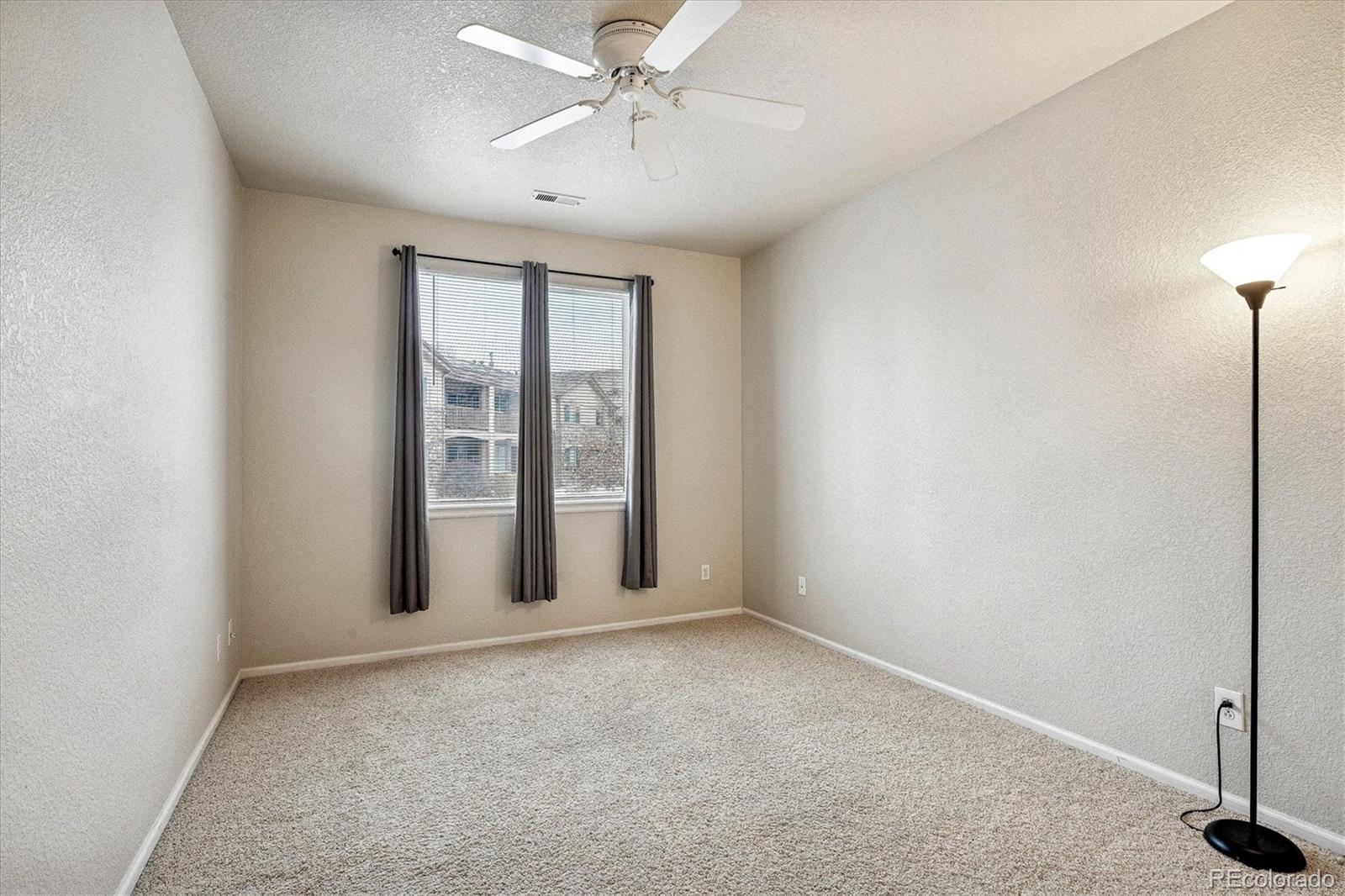 22960 East Roxbury Drive, Unit F Aurora, CO 80016 - Photo 18 of 43 an empty room with windows and fan