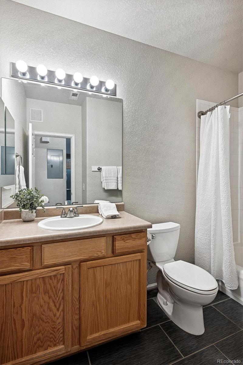 22960 East Roxbury Drive, Unit F Aurora, CO 80016 - Photo 20 of 43 a bathroom with a toilet a sink and mirror
