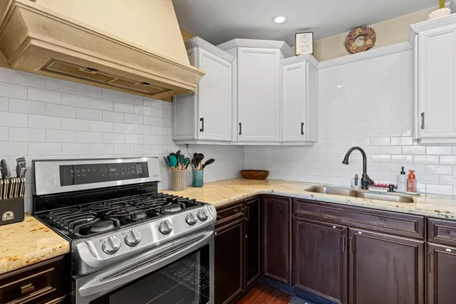a kitchen with stainless steel appliances a stove a sink dishwasher and cabinets with wooden floor