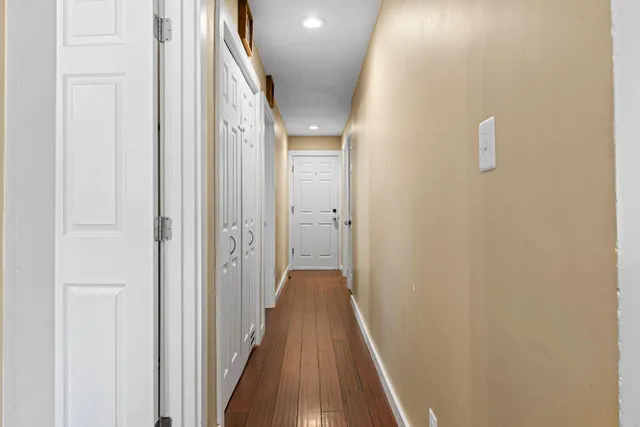 a view of a hallway with wooden floor