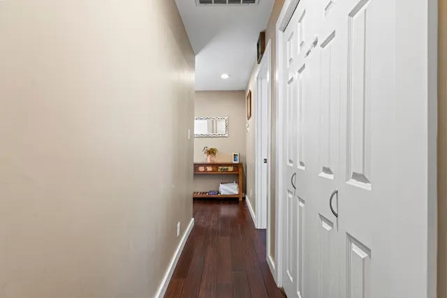 a view of a hallway with wooden floor and staircase