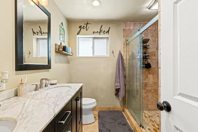 a bathroom with a granite countertop sink toilet and shower
