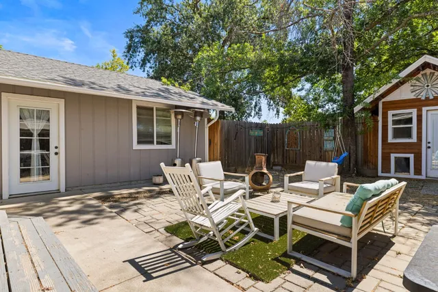 a view of a patio with table and chairs and wooden fence