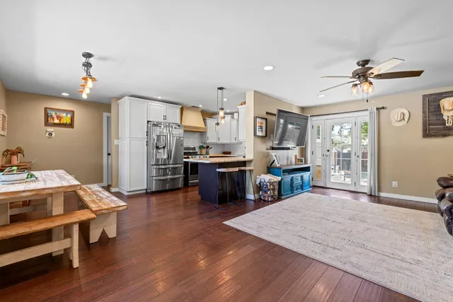 a living room with stainless steel appliances kitchen island furniture and wooden floor