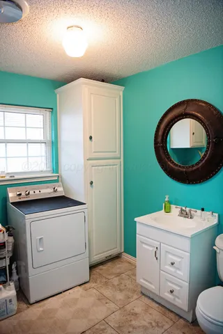a room with a washer dryer and a wooden cabinets