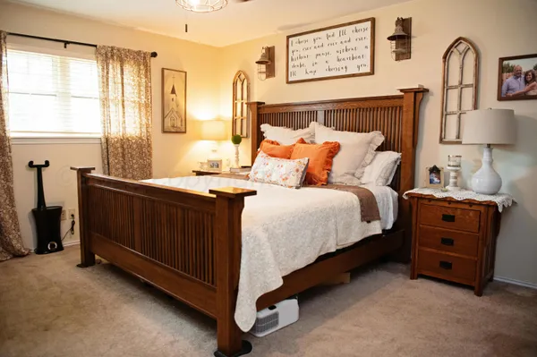 a bedroom with bed cabinet and window