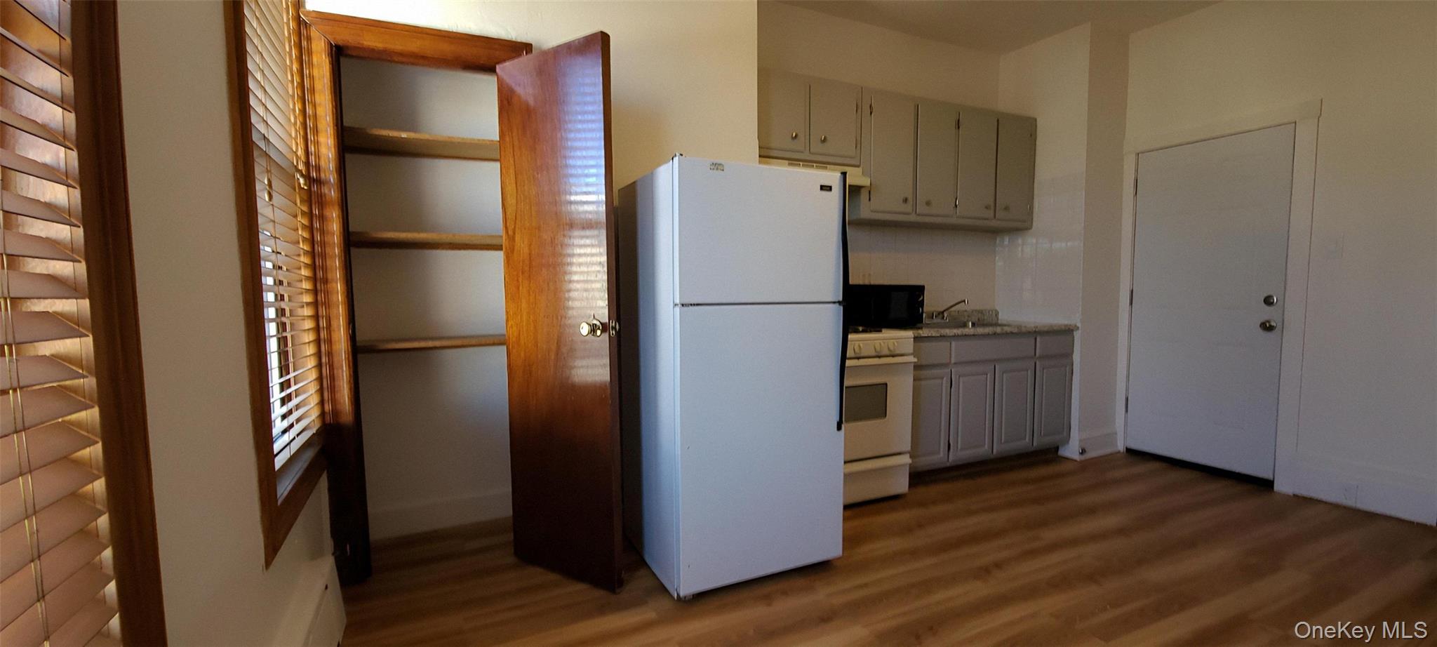 149 A 31st Street, Unit 2 Brooklyn, NY 11232 - Photo 4 of 8 a white refrigerator freezer and a wooden floor