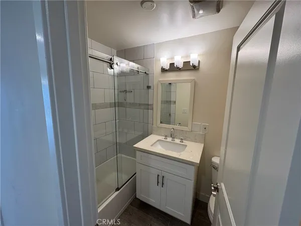 an empty room with wooden floor and a ceiling fan