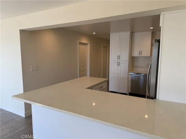 a kitchen with stainless steel appliances kitchen island a refrigerator sink and cabinets