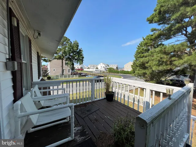 a view of a balcony with two chairs and wooden fence