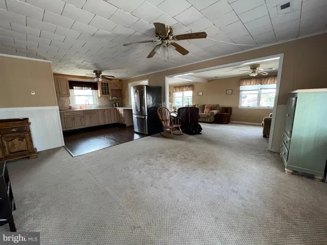 a view of a livingroom with furniture a ceiling fan and wooden floor