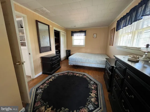 a bedroom with a bed and a mirror on the dresser