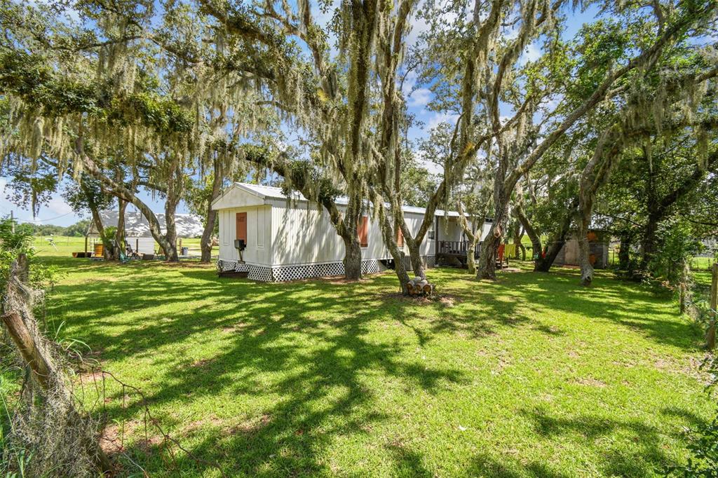 1101 Bird Road Davenport, FL 33837 - Photo 15 of 36 a backyard of a house with lots of green space and fountain