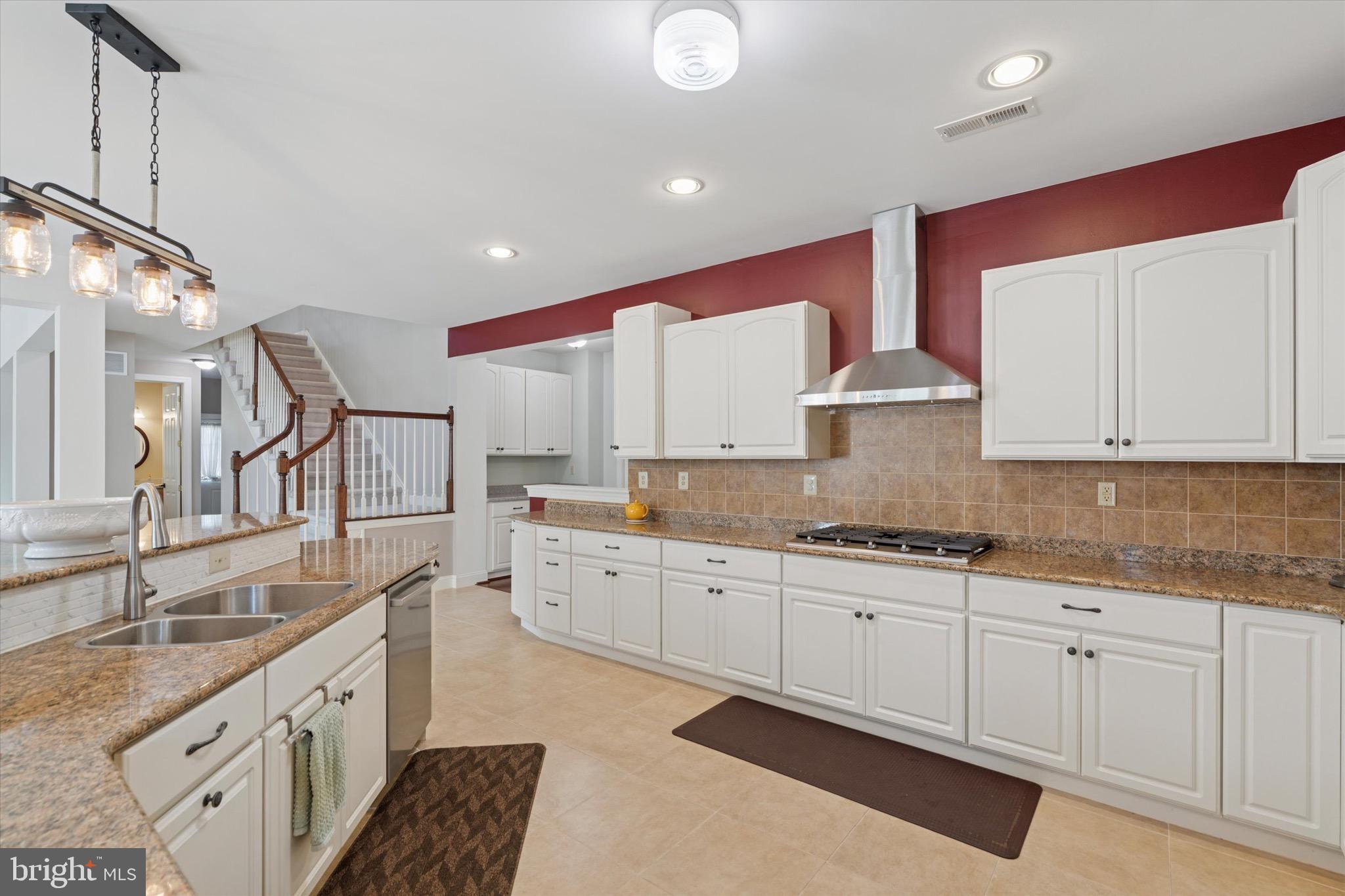 1375 Sloan Way Ambler, PA 19002 - Photo 18 of 54 a large kitchen with granite countertop a sink white cabinets and stainless steel appliances