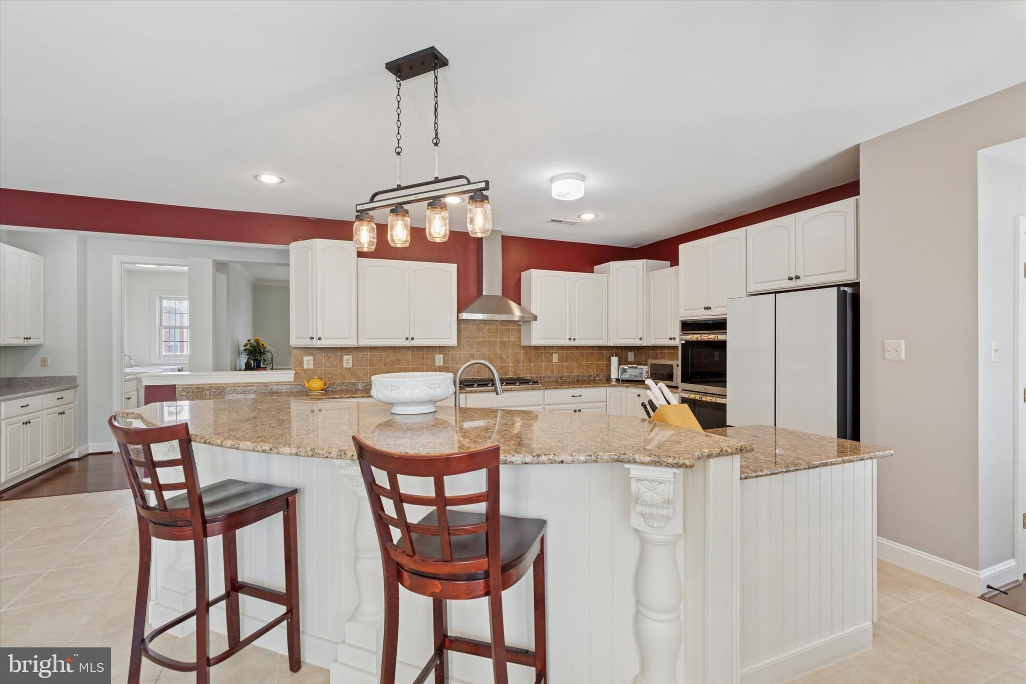 1375 Sloan Way Ambler, PA 19002 - Photo 19 of 54 a kitchen with stainless steel appliances kitchen island granite countertop a dining table chairs refrigerator and microwave