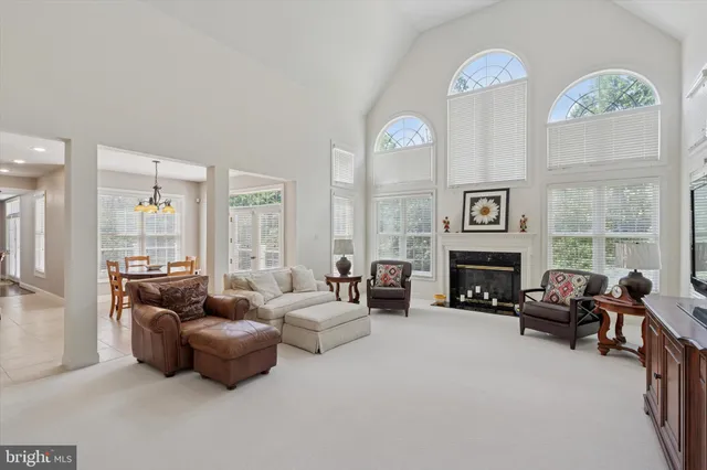 a living room with furniture a flat screen tv and a floor to ceiling window